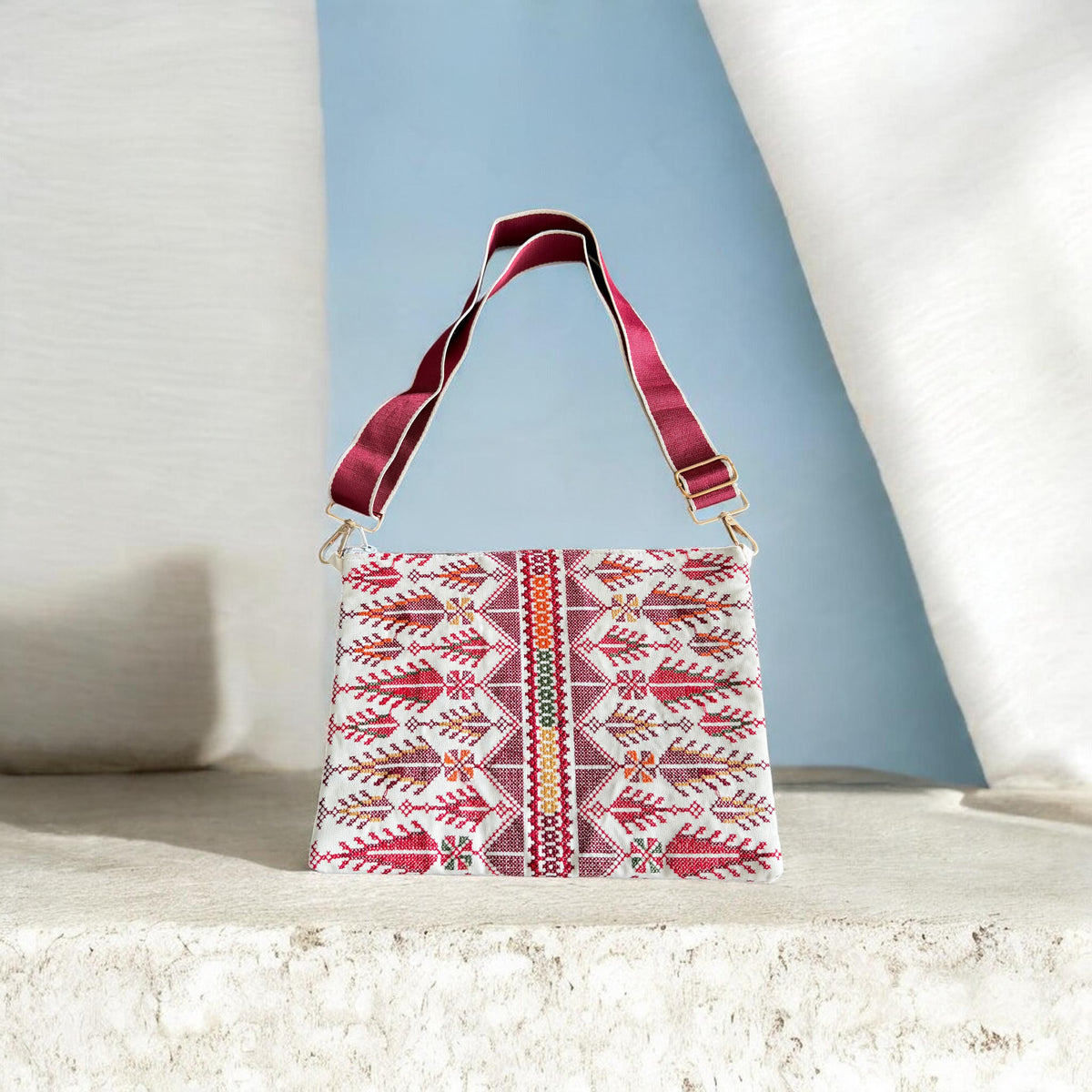 Cypress Tatreez Crossbody with burgundy strap, red cypress motifs and a central multicolored patterned band.