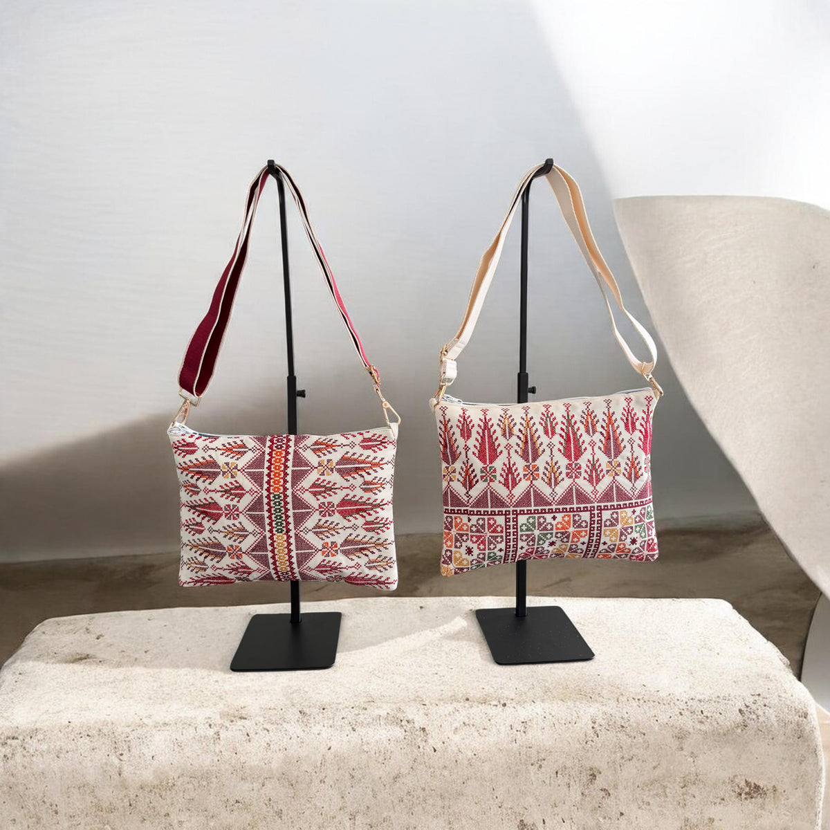 Burgundy-strap and cream-strap Cypress Tatreez Crossbody bags side by side, showing their different cypress motif layouts.