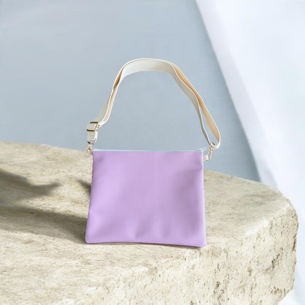 Back of the purple Najmeh Crossbody showing its plain lavender leather backing and cream strap
