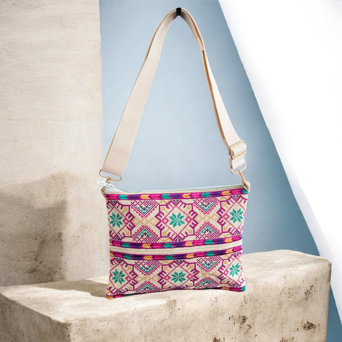 Najmeh Crossbody in purple shown from the front, with pink and green tatreez embroidery and a cream strap