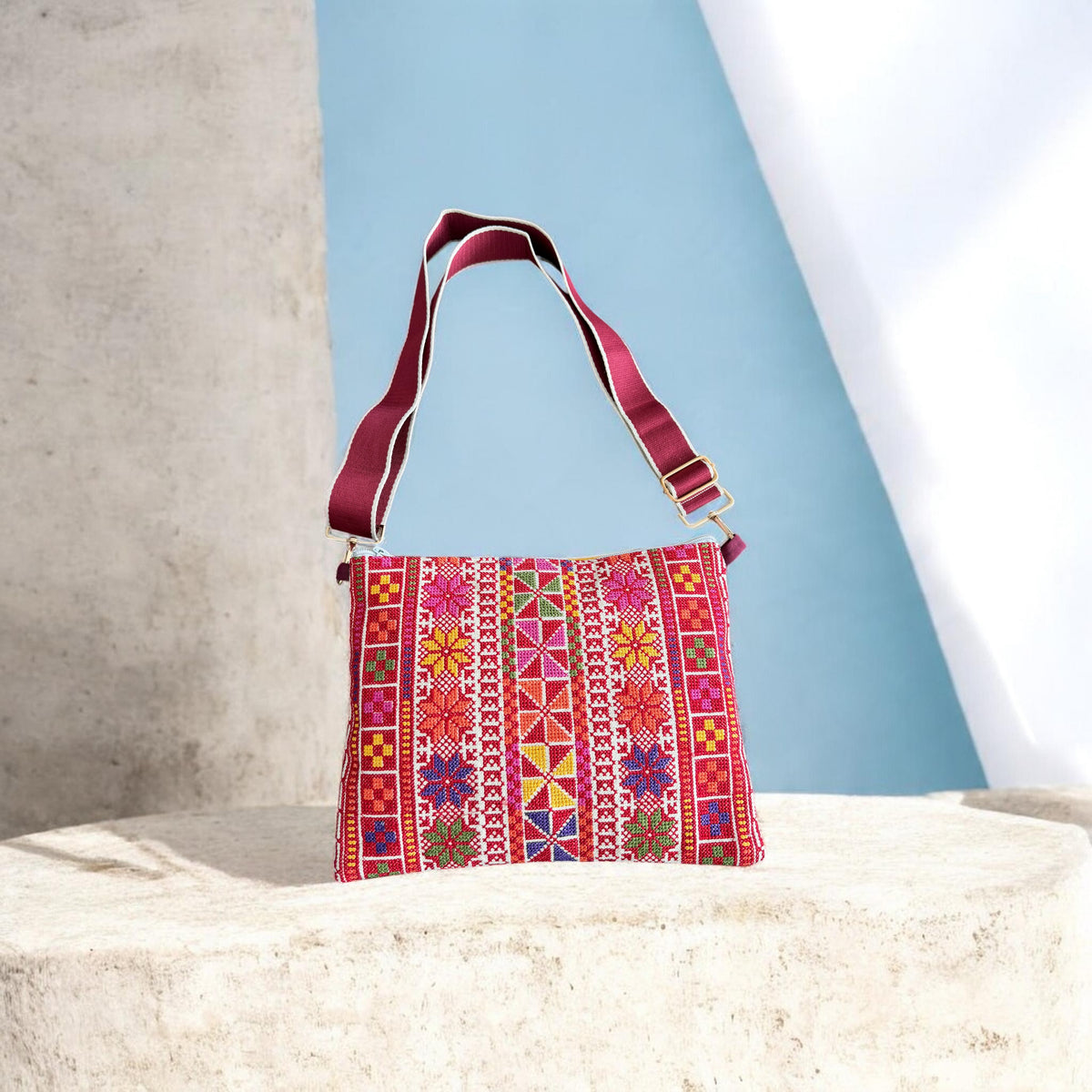 Najmeh Crossbody in red, with multicolored tatreez embroidery on the front and a burgundy adjustable strap