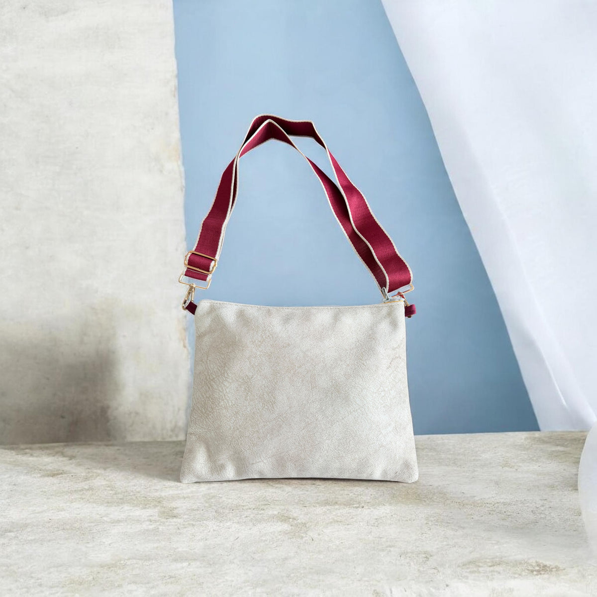 Back of the red Najmeh Crossbody showing its plain cream velvet backing and burgundy strap