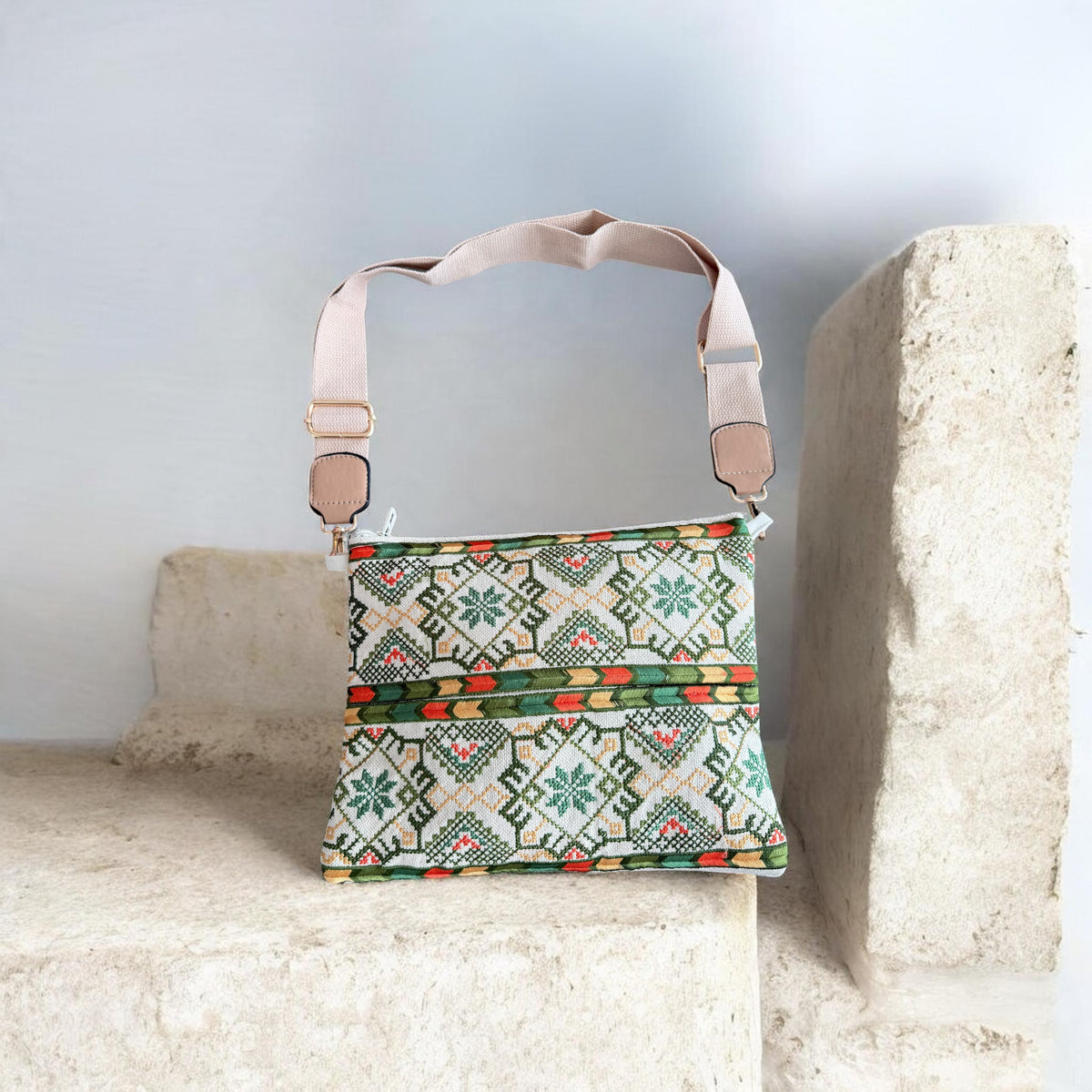Najmeh Crossbody in green, with green and red tatreez embroidery on the front and a taupe adjustable strap