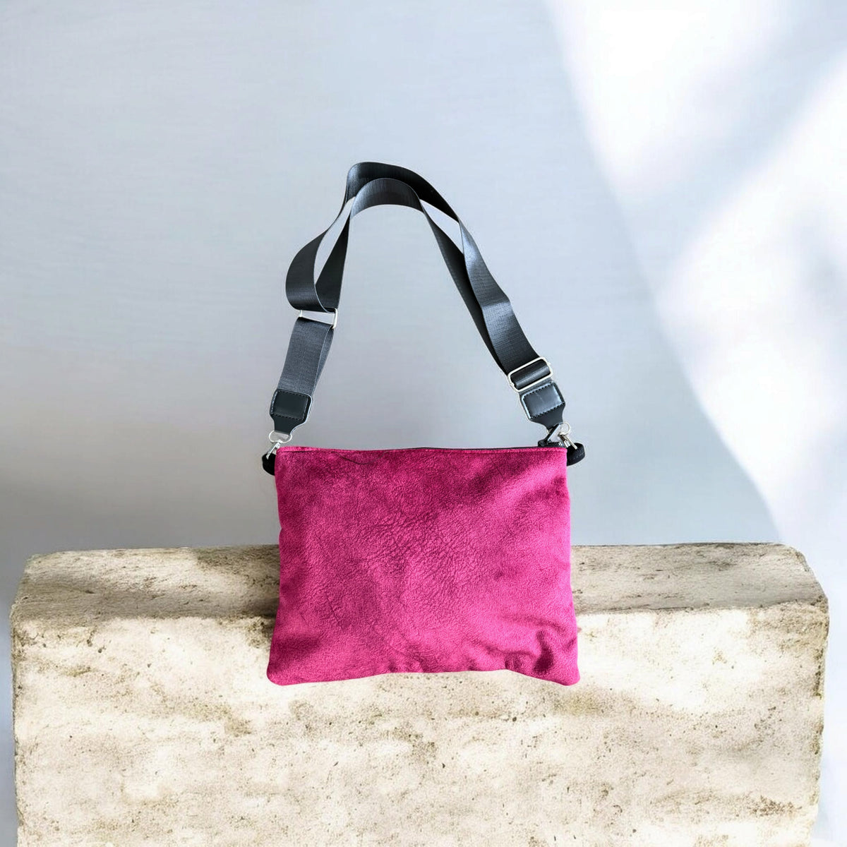 Back of red Sinsal Crossbody showing burgundy velvet fabric and an adjustable black strap.