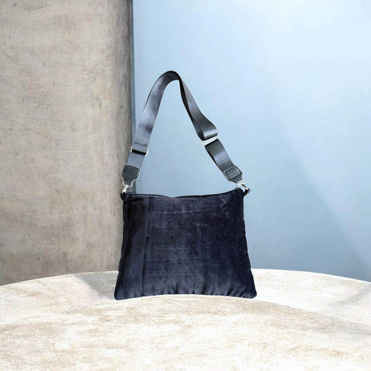 Rear view of black velvet Sinsal Crossbody with an adjustable black strap and silver-tone clips.