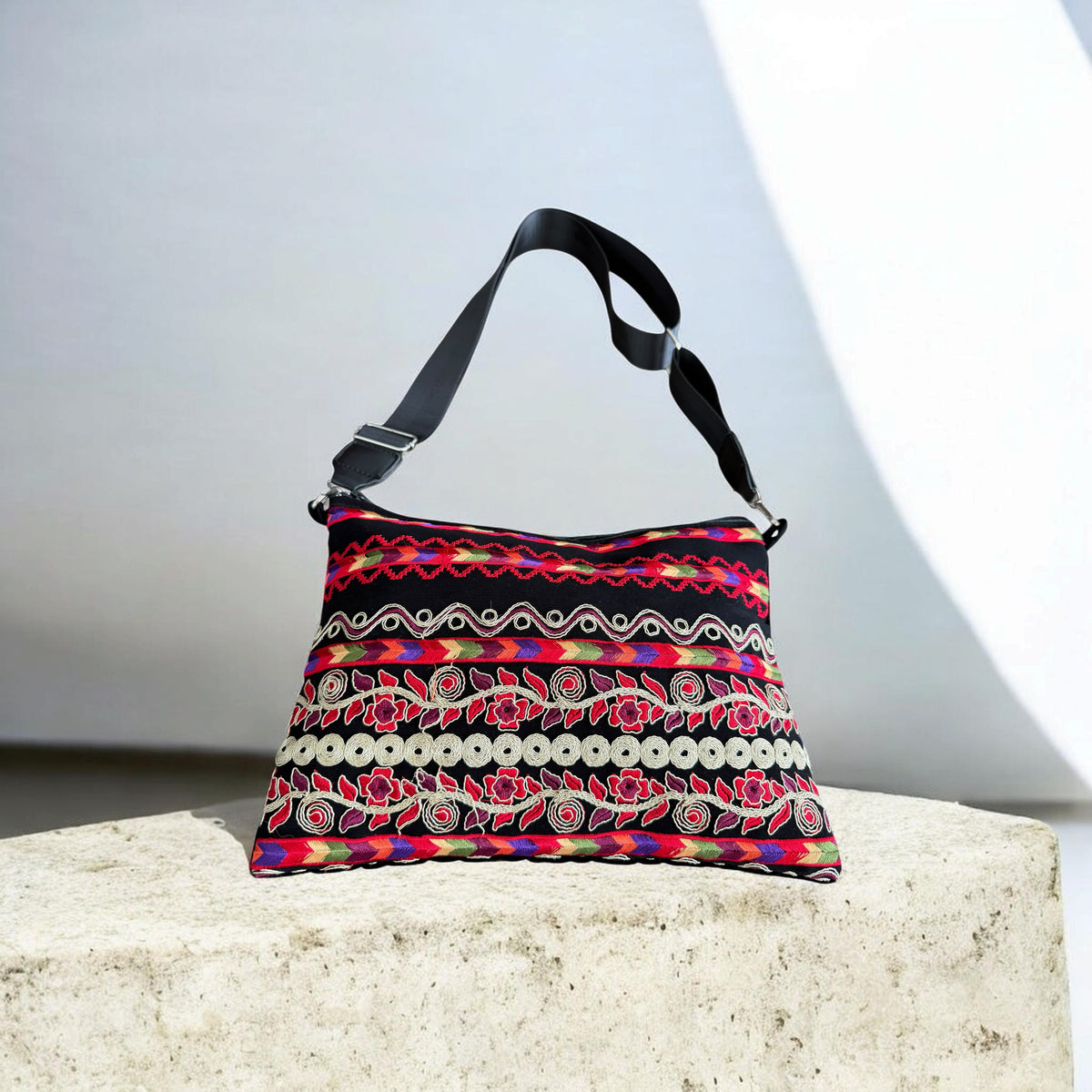  Sinsal Crossbody with horizontal red floral embroidery, multicolor bands, and circular trim on black fabric.