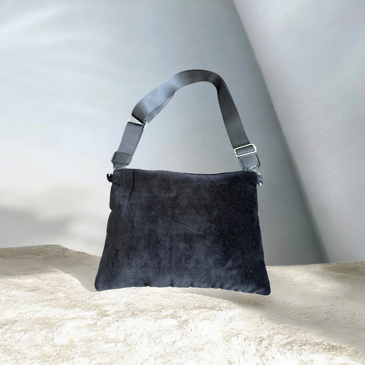 Back of Sinsal Crossbody showing black velvet fabric and a black strap with silver-tone hardware.