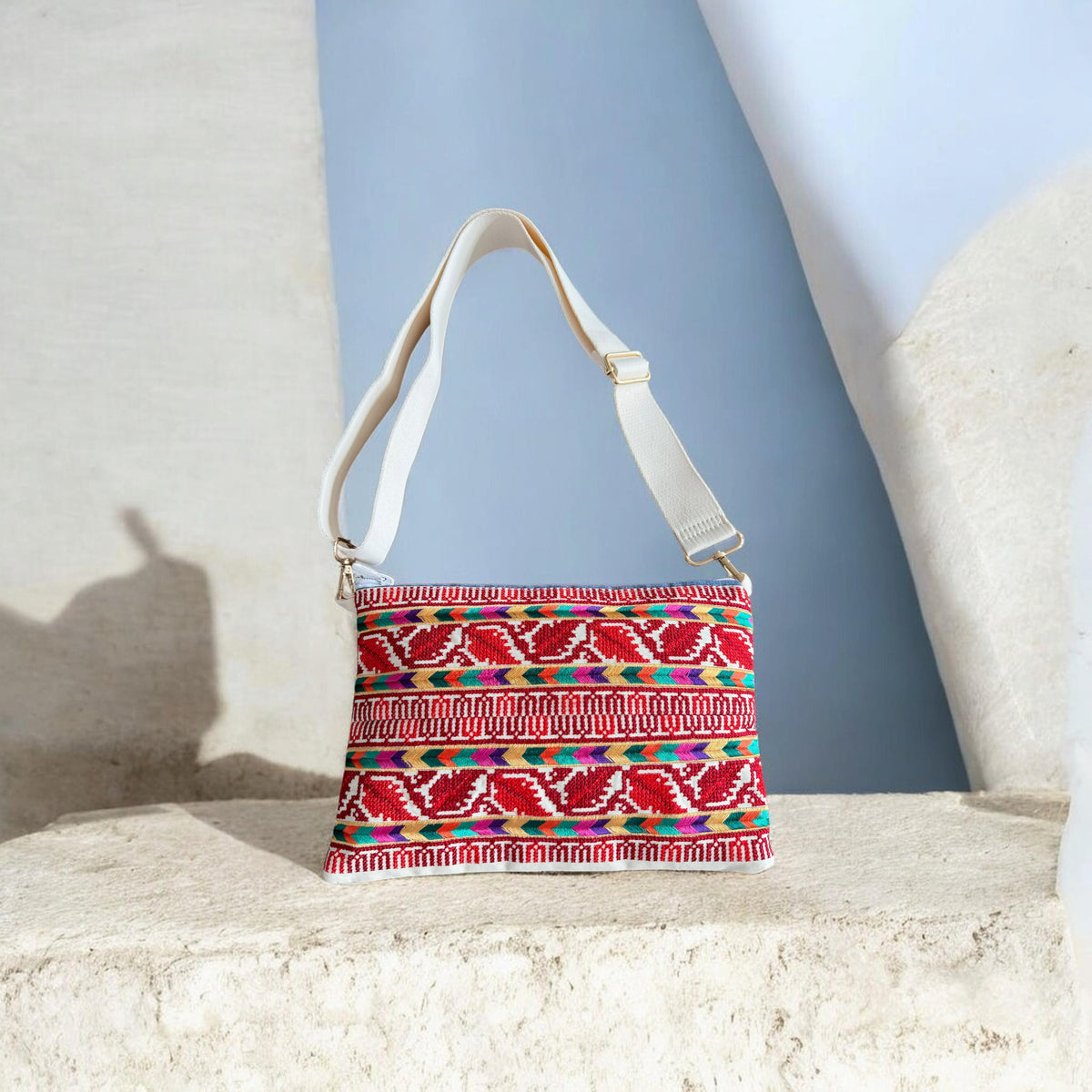 Sabaleh Crossbody with red and cream tatreez, multicolor bands, and an adjustable cream strap with gold-tone hardware.