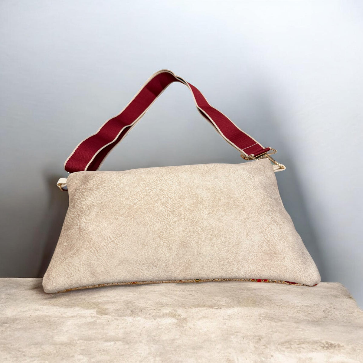 Back of the Sarw Crossbody showing cream velvet, a burgundy adjustable strap, and gold-tone hardware.