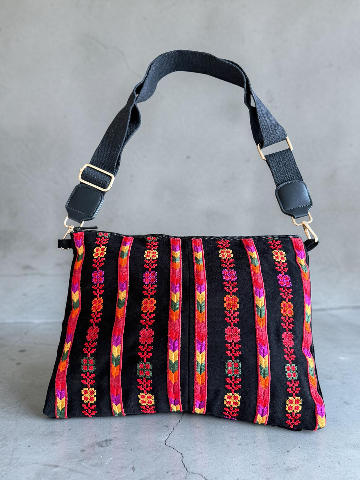 Nafnoof Crossbody in black velvet with colorful vertical Palestinian Tatreez floral motifs and a short black strap.