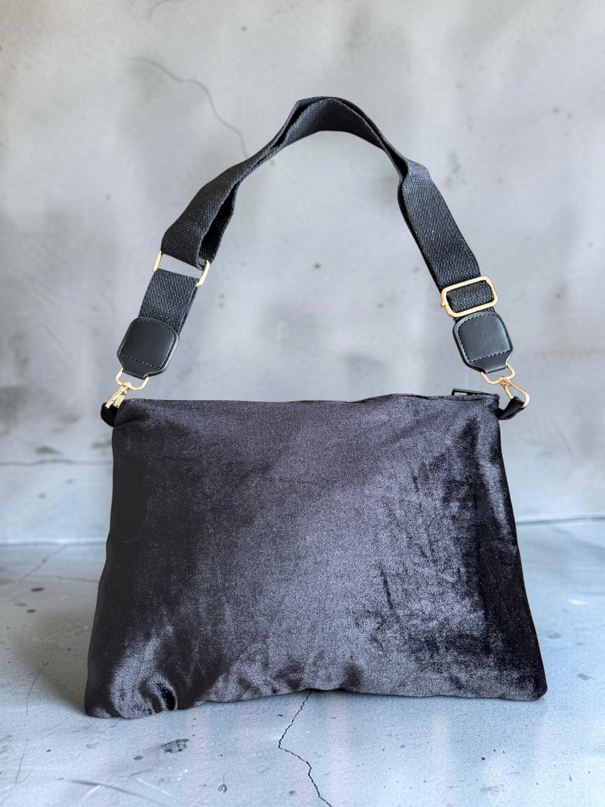 Back of the Nafnoof Crossbody showing plain black velvet and an adjustable black strap with metal clasps.